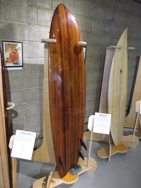 Asymmetrical redwood surfboard made from the wood of a large wine barrel, created by Carl Ekstrom.