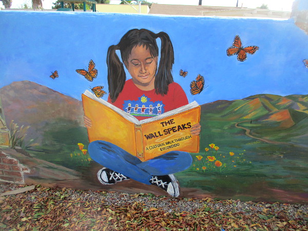 Child learns about the culture and history of Escondido reading a book titled The Wall Speaks.